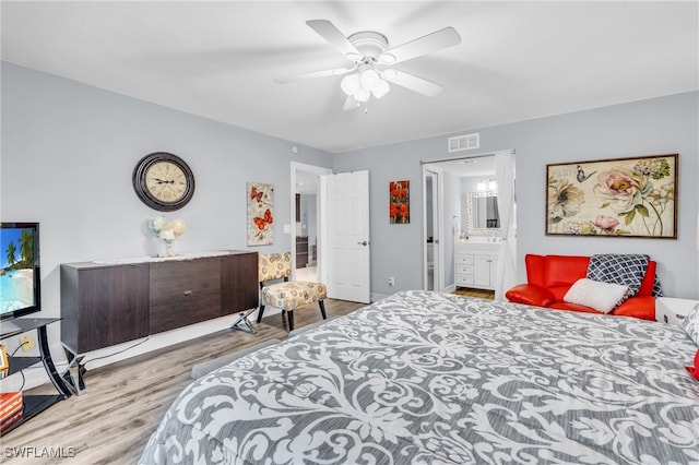 bedroom featuring light hardwood / wood-style flooring, ceiling fan, and connected bathroom