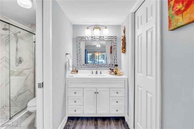 bathroom featuring hardwood / wood-style flooring, vanity, toilet, and a shower with door