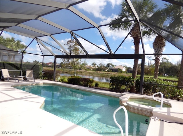 view of pool with an in ground hot tub, a water view, glass enclosure, and a patio area