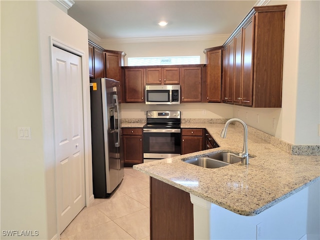 kitchen with kitchen peninsula, appliances with stainless steel finishes, sink, and light stone counters