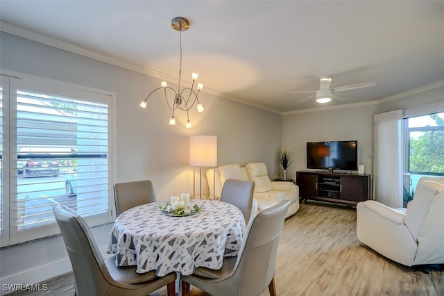 dining area featuring crown molding, ceiling fan with notable chandelier, and light wood-type flooring