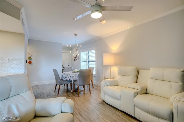 living room featuring ceiling fan with notable chandelier, light hardwood / wood-style floors, and crown molding