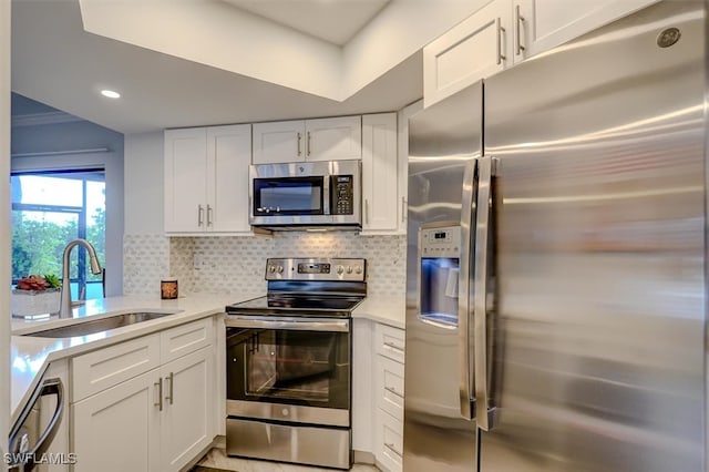 kitchen featuring white cabinets, sink, appliances with stainless steel finishes, and tasteful backsplash