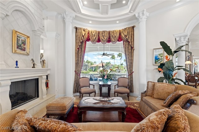 sitting room featuring ceiling fan, coffered ceiling, ornate columns, and crown molding