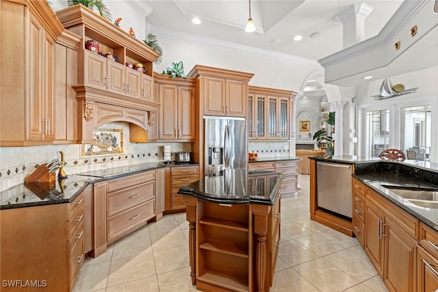 kitchen featuring stainless steel appliances, dark stone countertops, a kitchen island, and ornamental molding