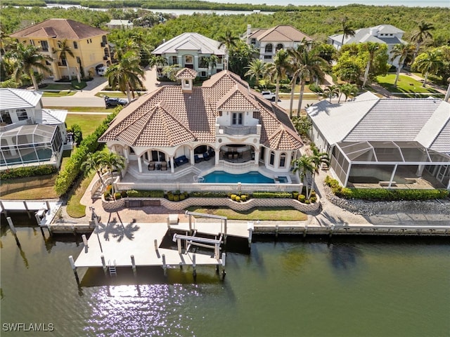 back of house featuring glass enclosure and a water view