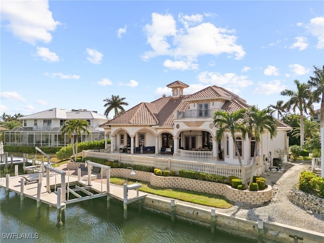 back of property featuring a balcony, a patio, and a water view