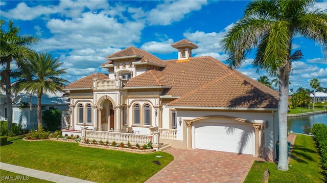 mediterranean / spanish house featuring a water view, a garage, a porch, a balcony, and a front lawn