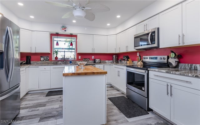 kitchen with white cabinetry, a kitchen island, and appliances with stainless steel finishes