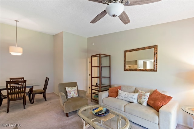 living room with a textured ceiling, light colored carpet, and ceiling fan