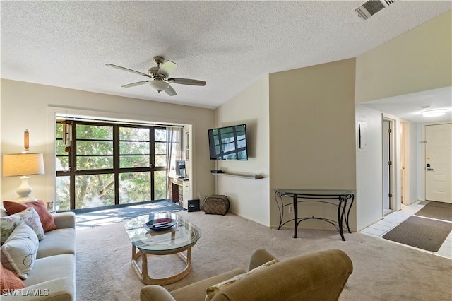 living room featuring ceiling fan, a textured ceiling, and light carpet