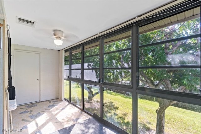 unfurnished sunroom featuring ceiling fan