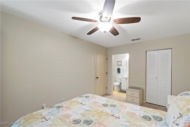 bedroom with ceiling fan, a textured ceiling, a closet, and connected bathroom