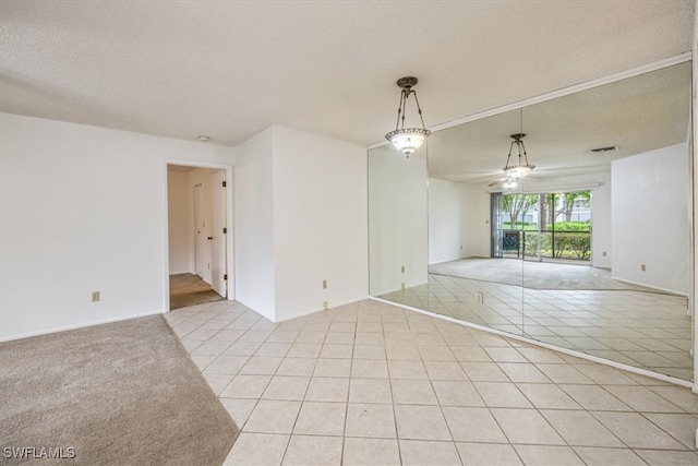 tiled empty room featuring a textured ceiling and ceiling fan