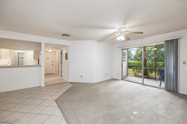 unfurnished living room featuring light tile patterned floors, ceiling fan, visible vents, and a textured ceiling