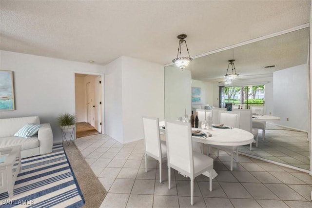 dining space with visible vents, a textured ceiling, and light tile patterned floors