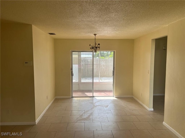 unfurnished room featuring a notable chandelier, light tile patterned floors, and a textured ceiling