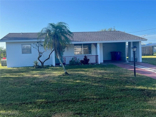 ranch-style house featuring a front lawn, covered porch, and a carport