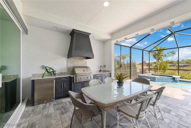 view of patio featuring glass enclosure, sink, exterior kitchen, a grill, and an in ground hot tub