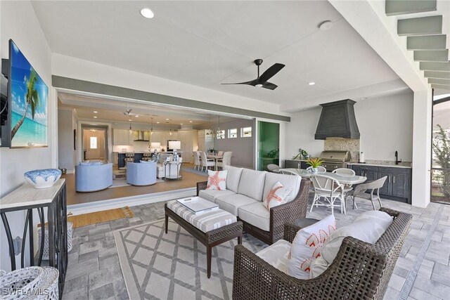 view of patio with outdoor lounge area, sink, and grilling area