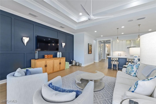 living room with ceiling fan, light hardwood / wood-style floors, and ornamental molding