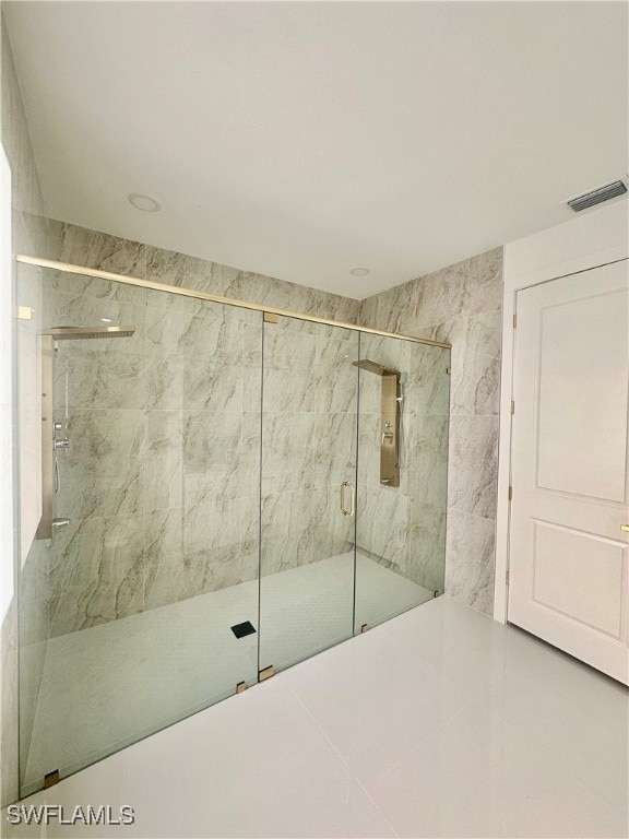 bathroom with tile walls, tile patterned flooring, and a shower with door