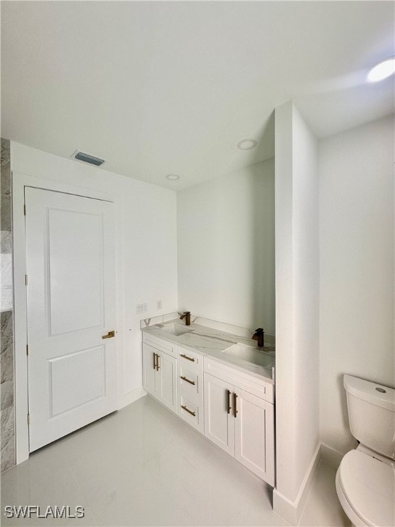 bathroom featuring toilet and vanity