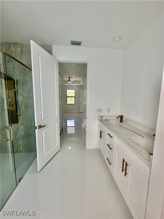 bathroom with an enclosed shower, vanity, and tile patterned floors