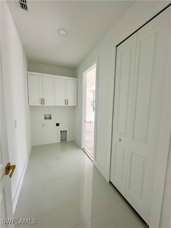 laundry area with washer hookup, cabinets, and light tile patterned flooring