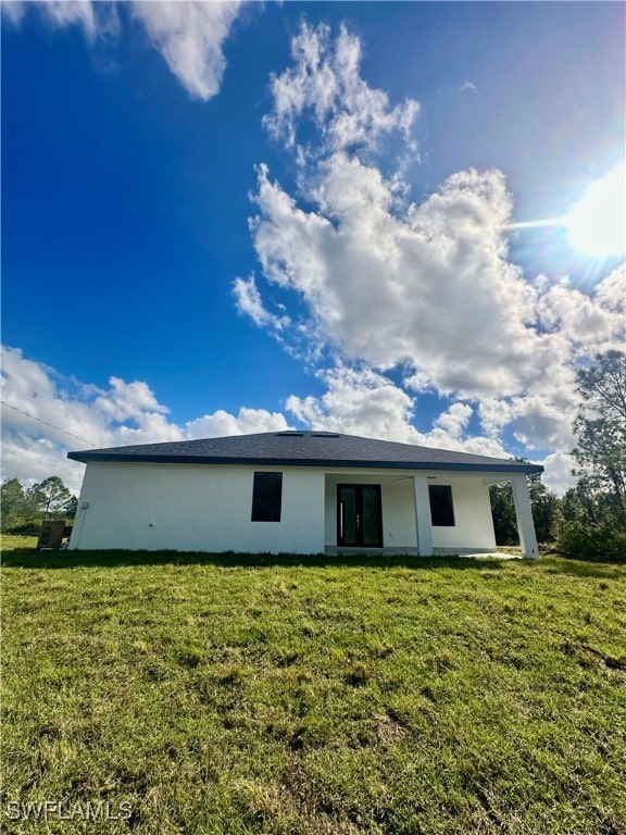 back of property featuring a lawn