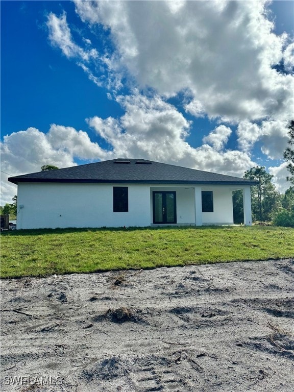 back of house featuring a lawn