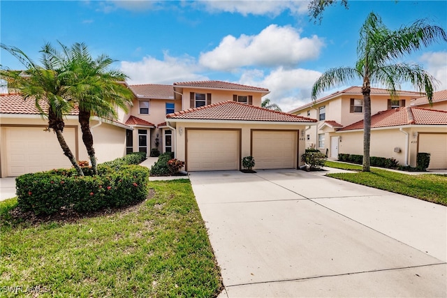 mediterranean / spanish-style house with a garage and a front lawn