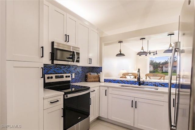 kitchen featuring white cabinets, sink, decorative light fixtures, and appliances with stainless steel finishes