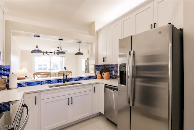 kitchen with tasteful backsplash, appliances with stainless steel finishes, sink, and white cabinets