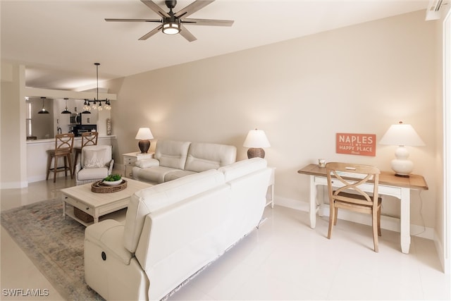 living room with ceiling fan with notable chandelier