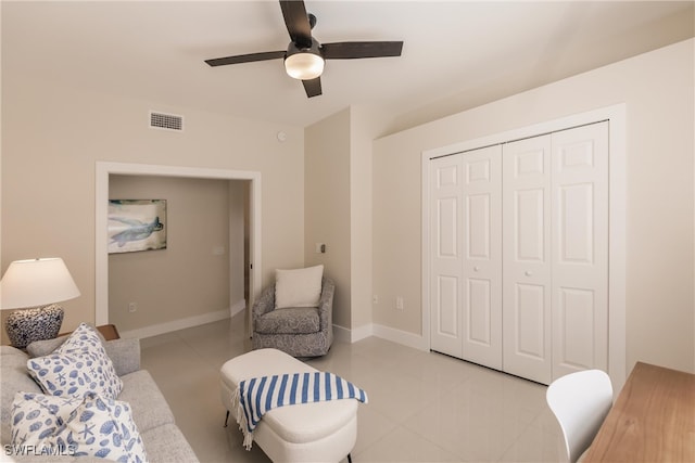 tiled living room with ceiling fan