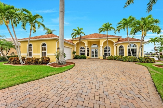 mediterranean / spanish house featuring a front yard, french doors, and a garage