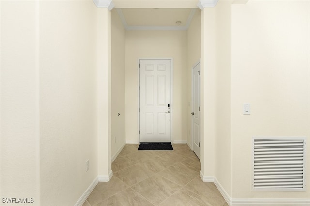 hallway featuring light tile patterned floors, ornate columns, and ornamental molding