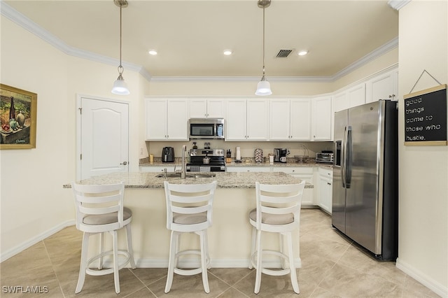 kitchen with stainless steel appliances, white cabinets, an island with sink, and pendant lighting