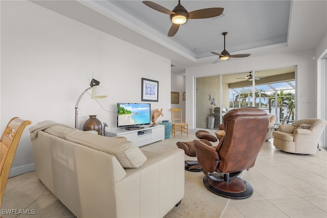 living room with light tile patterned floors, a raised ceiling, and ceiling fan