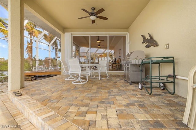 view of patio featuring glass enclosure, a grill, and ceiling fan