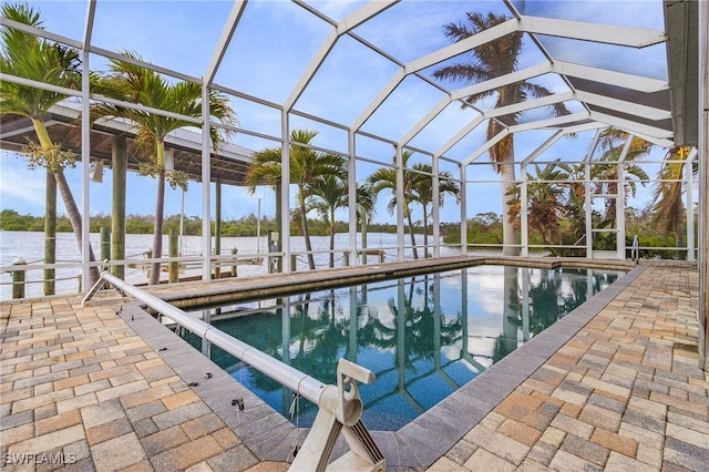 view of swimming pool with a lanai, a water view, and a patio area