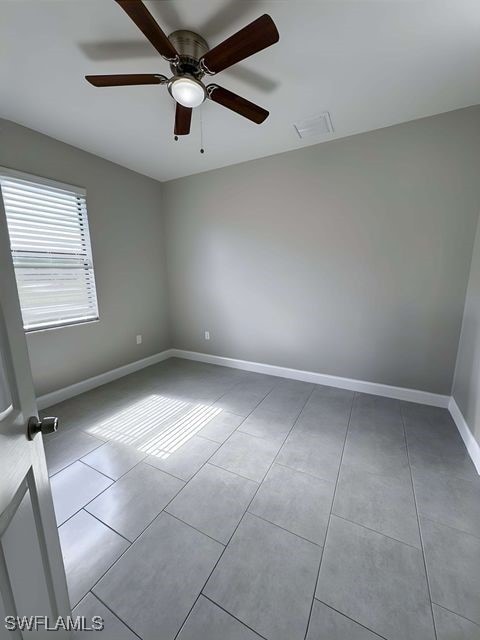 tiled empty room with ceiling fan