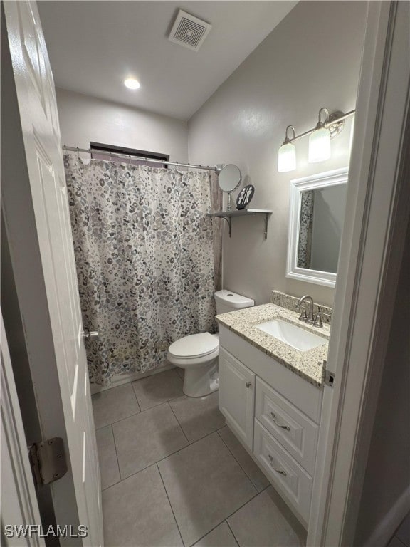 bathroom featuring tile patterned floors, vanity, toilet, and walk in shower