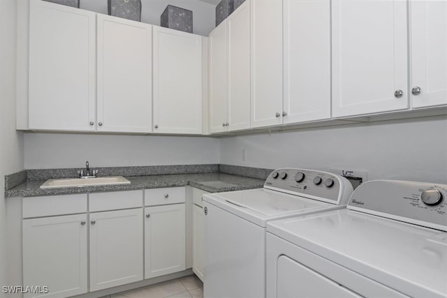 clothes washing area featuring washing machine and clothes dryer, light tile patterned flooring, cabinets, and sink