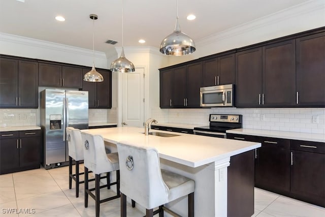 kitchen featuring dark brown cabinetry, a kitchen island with sink, sink, and appliances with stainless steel finishes