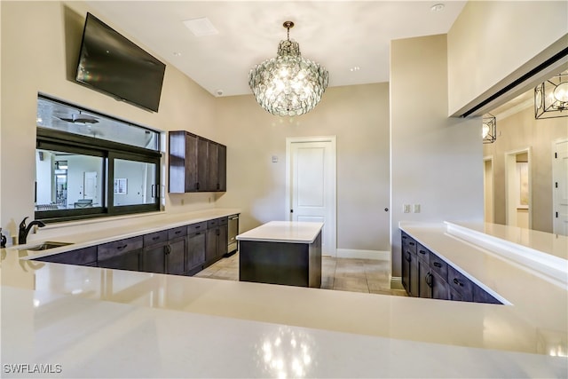 kitchen with dark brown cabinetry, sink, hanging light fixtures, a chandelier, and a kitchen island