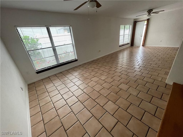 empty room with a ceiling fan and baseboards