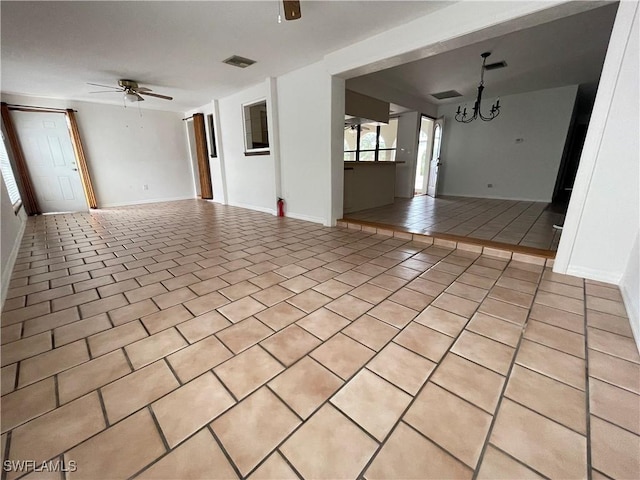 interior space with light tile patterned flooring and ceiling fan with notable chandelier