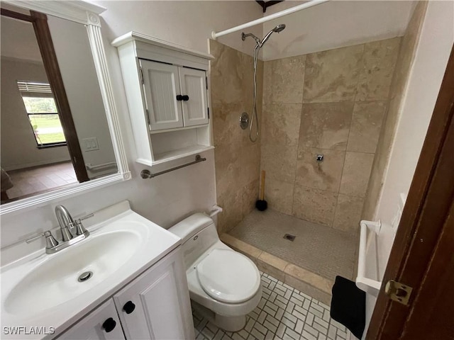 bathroom with vanity, a tile shower, tile patterned floors, and toilet